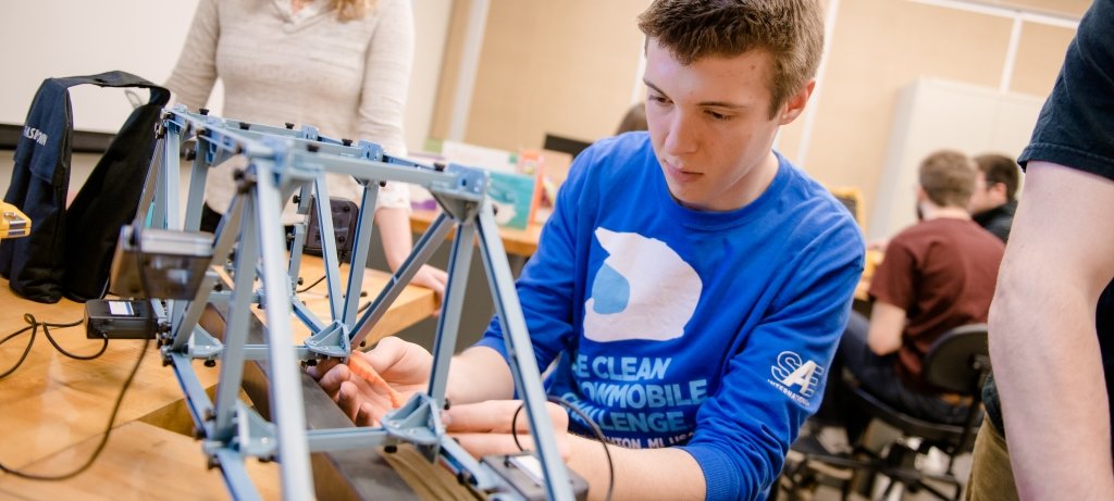 A student working on a scale bridge.