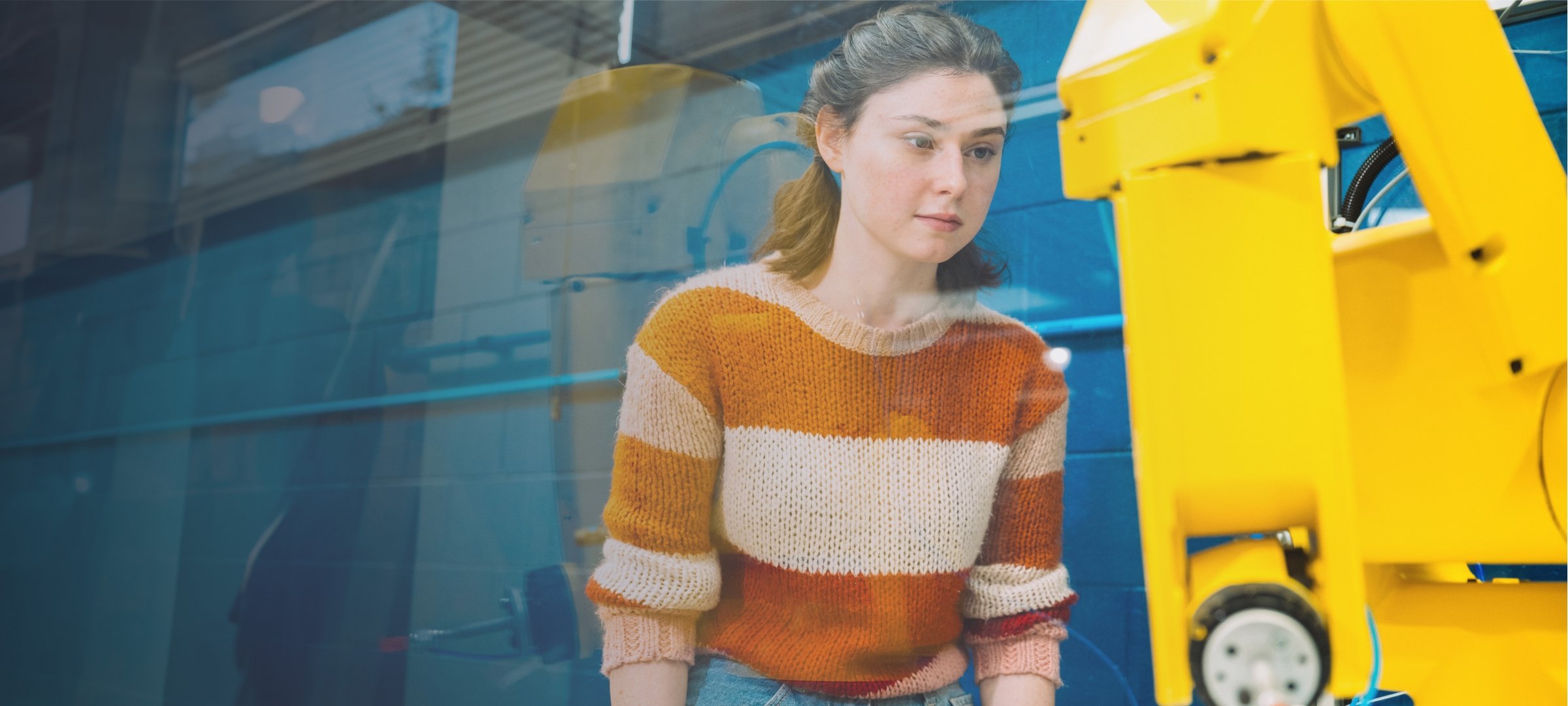 Student looking at a robotic arm.