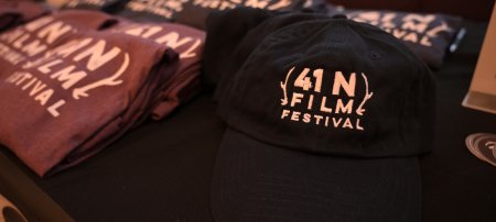 A table with hats and t-shirts featuring the 41N Film Festival logo.