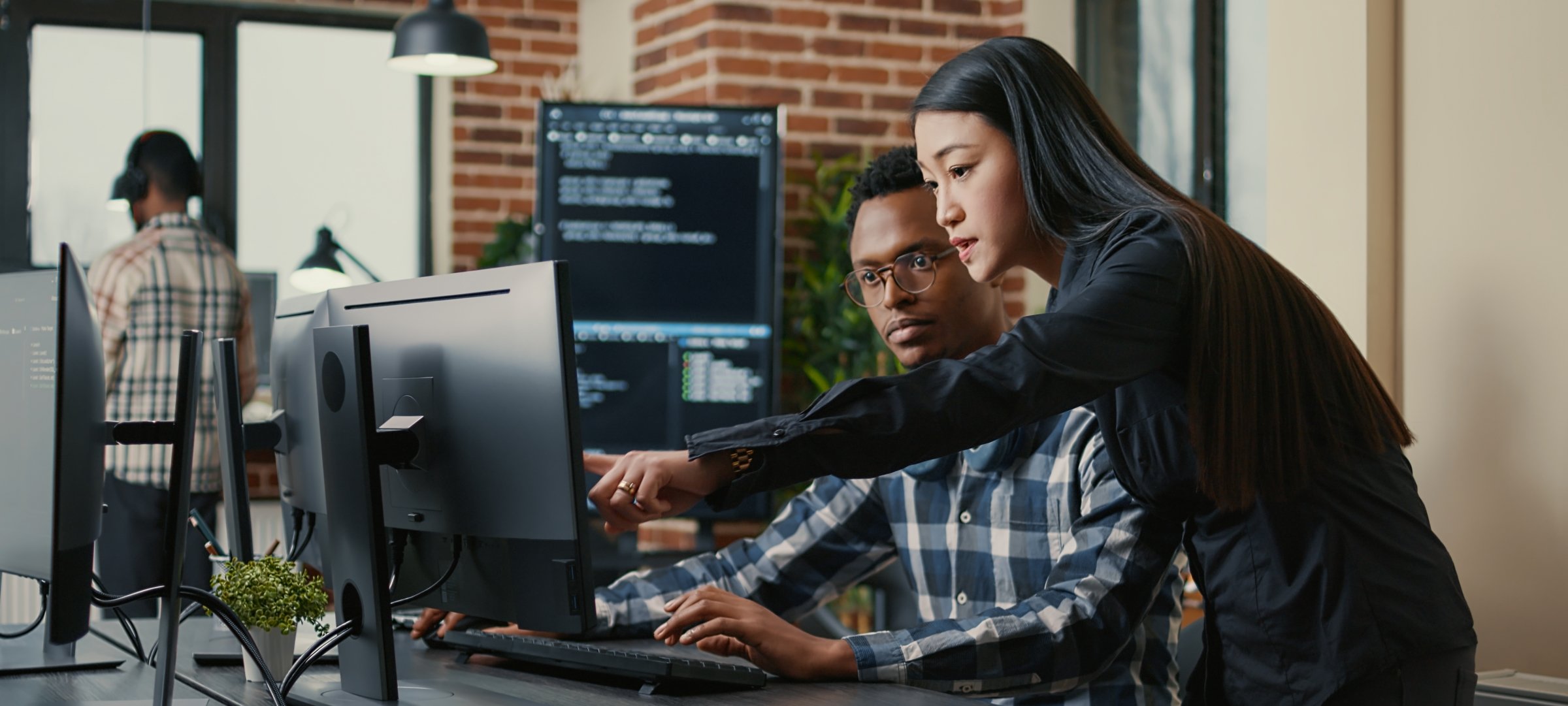 Two grad students looking and pointing at a computer screen