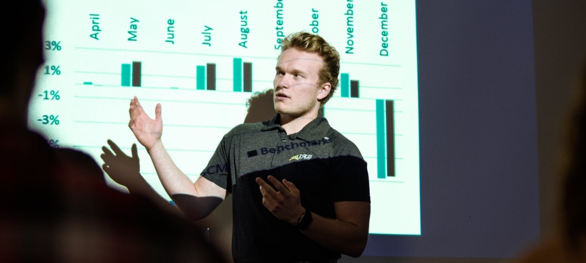 Student in front of a screen with graphs.