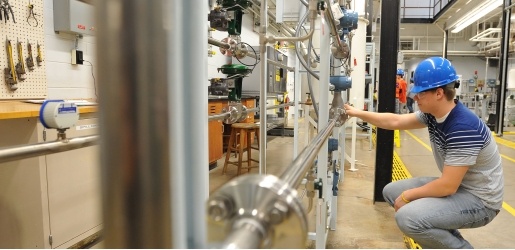 Student looking at pipes in the Unit Operations lab.