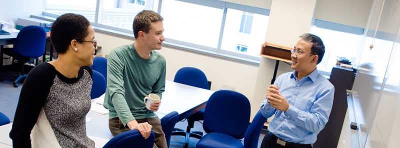 Dr. Wang talking with two students