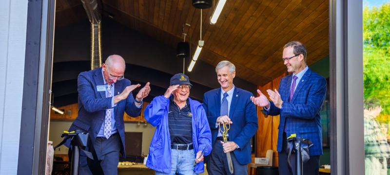 Four representatives stand and celebrate after cutting ceremonial ribbon.