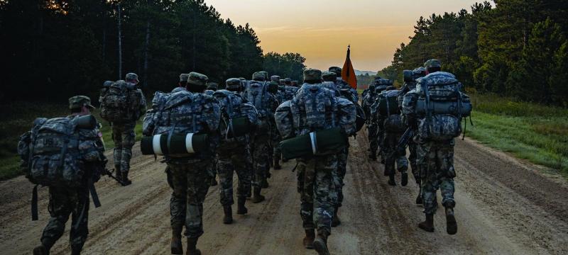 ROTC cadets running down a dirt road.