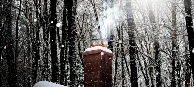 Smoke coming out of a snowy chimney.