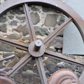 Wooden wheel leaning against a brick wall