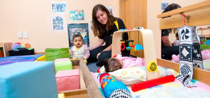 Teacher playing with two infants.