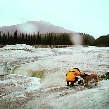 Person and dog next to water.