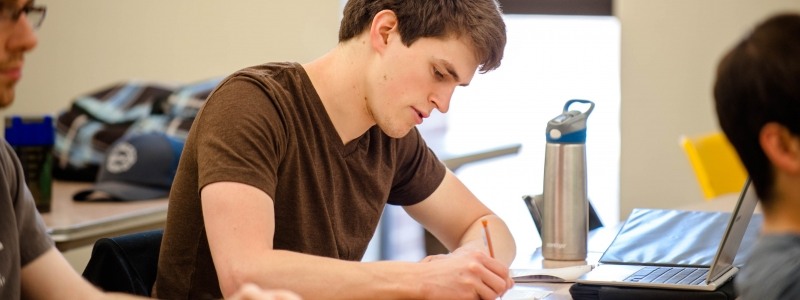 Student taking notes during a lecture.