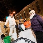 Students standing by a snow statue.